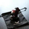 black dog chastity cage up right with keys on black bag