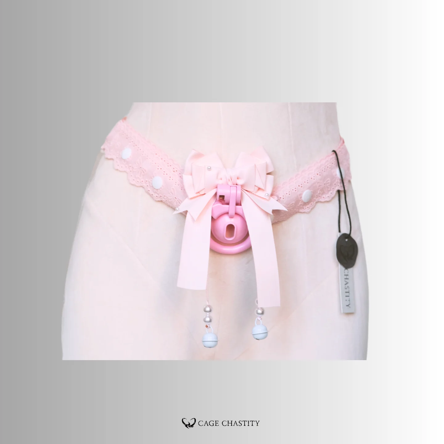 pink lace strap with two white bells and a pink cage
