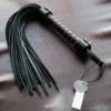 the flogger whip on a brown leather surface