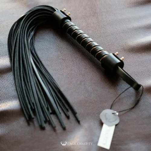 the flogger whip on a brown leather surface