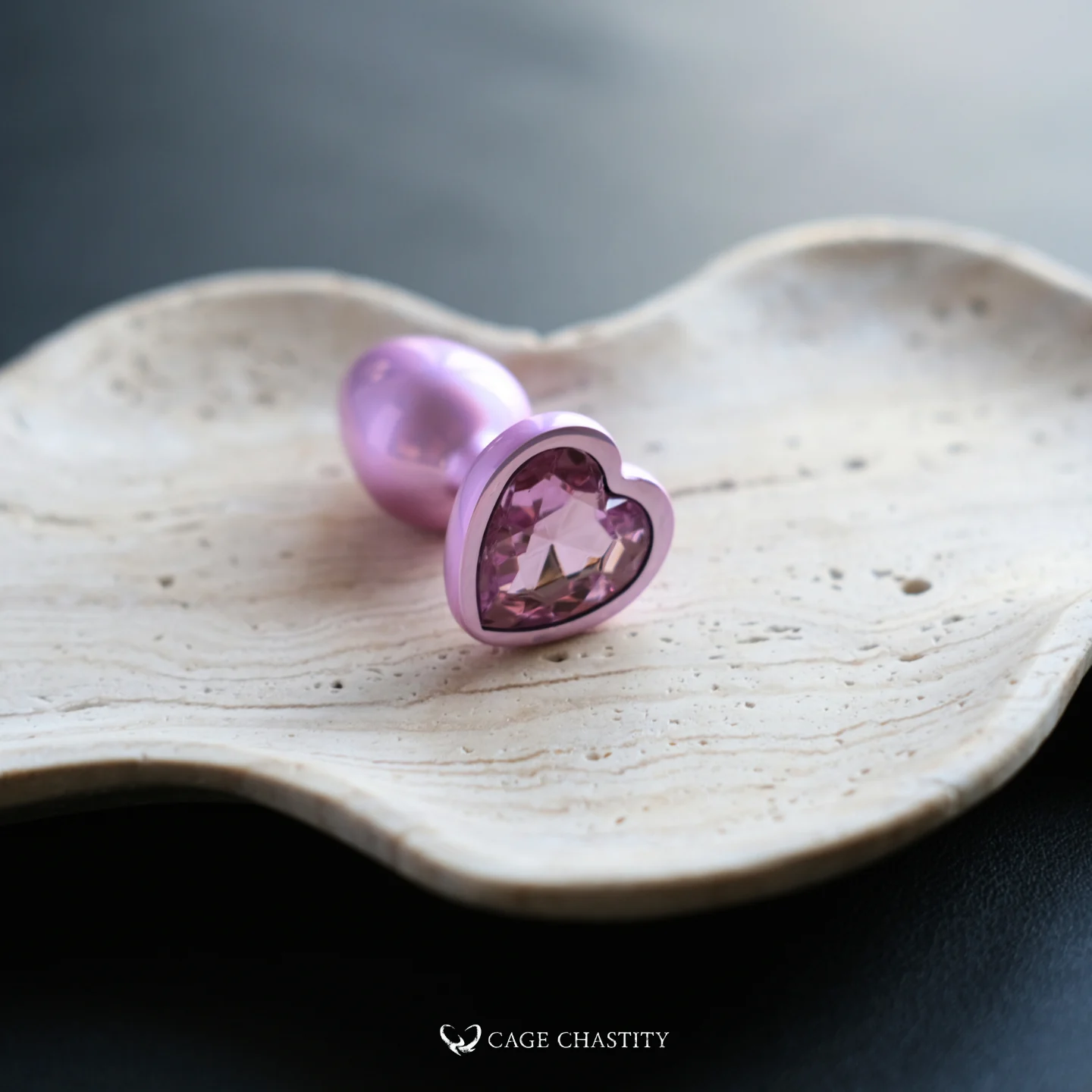 the pink heart butt plug on a wood plate